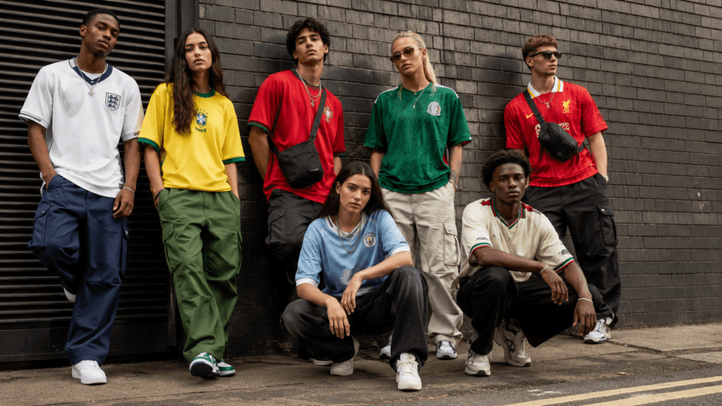 Stylish young adults wearing football shirt streetwear outfits in 2026 with oversized jerseys, cargos and trainers